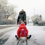 person pulling cart with boy